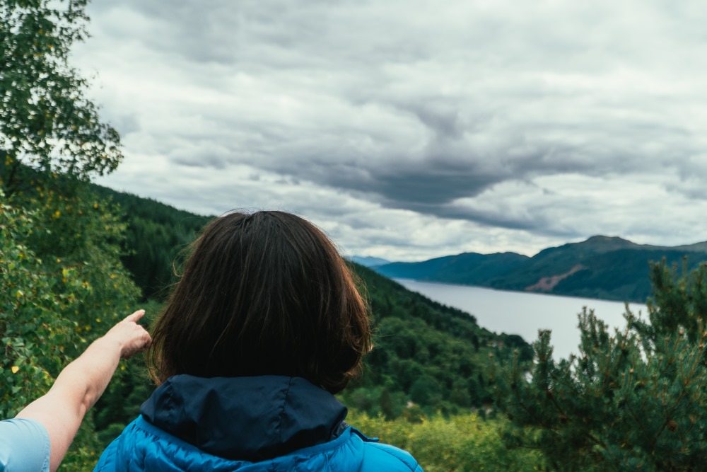 A walker pointing out a nice view of Loch Ness to a friend