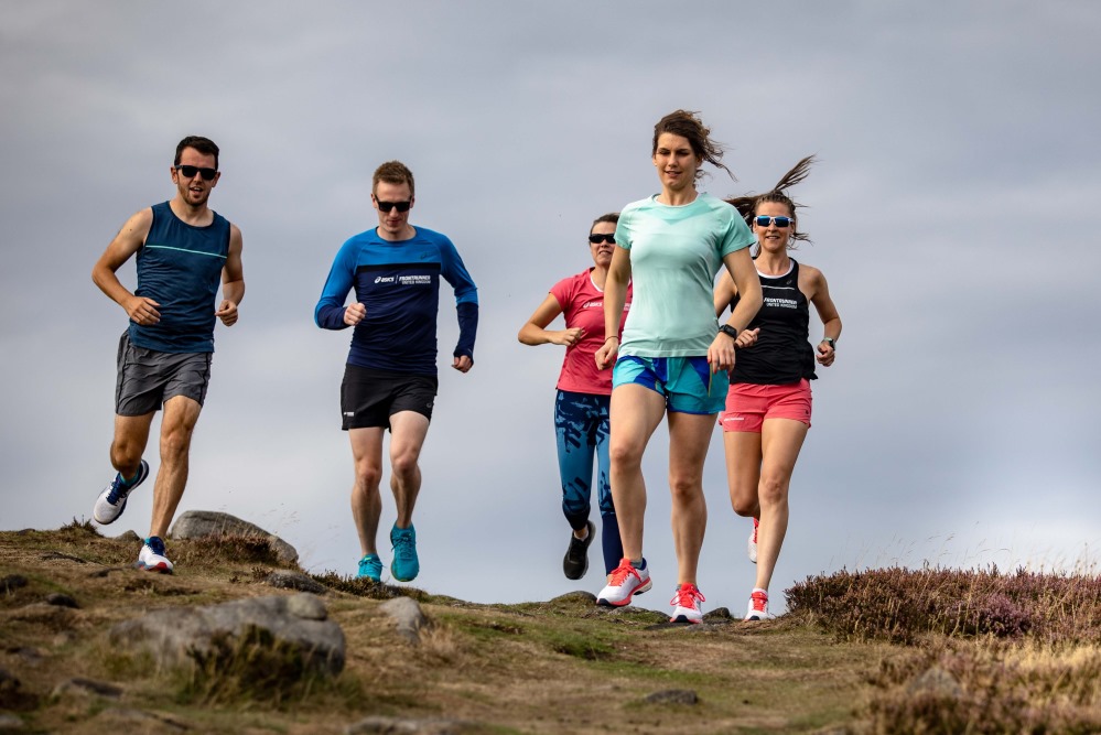 Group of male and female runners on a trail
