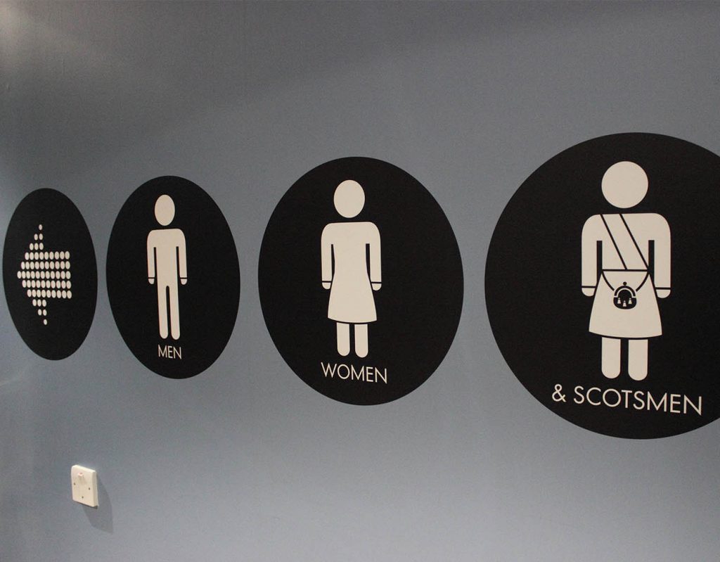 A Scottish sign for the toilets, including an image of a man in a kilt. 