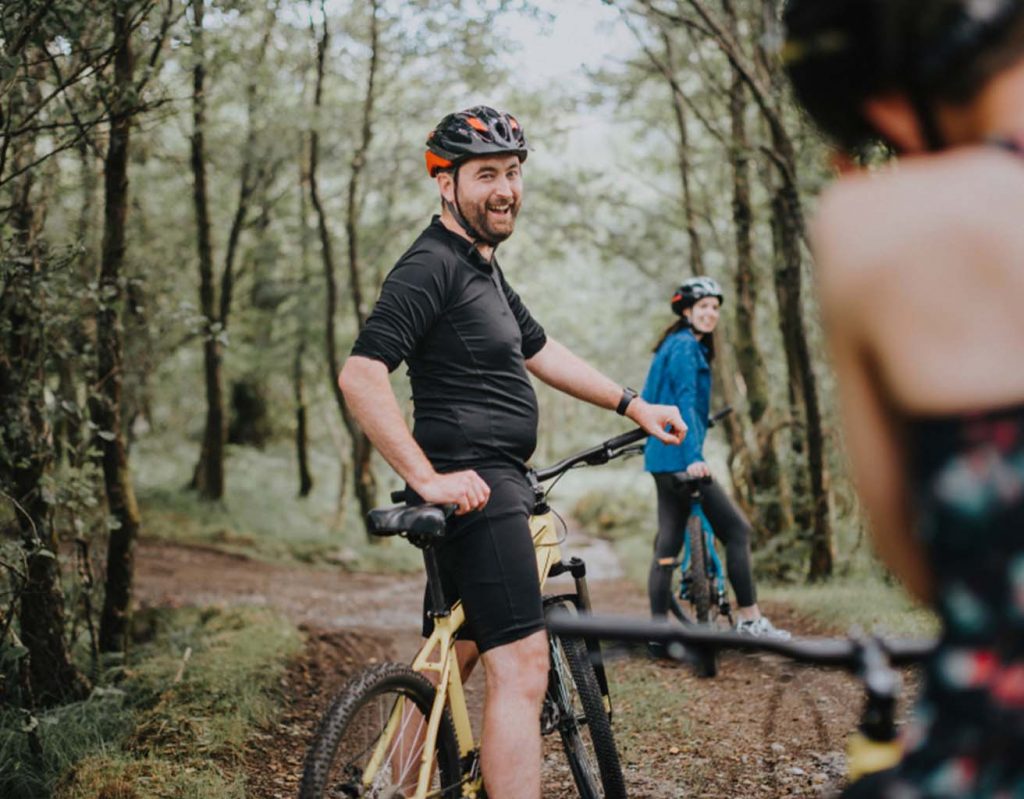 A man and friends biking in the woods.