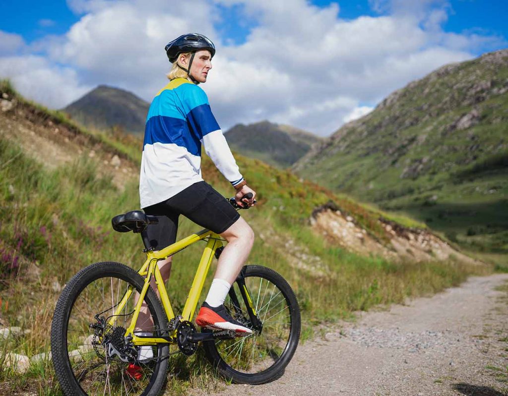 A man pauses on his bike in the hills.